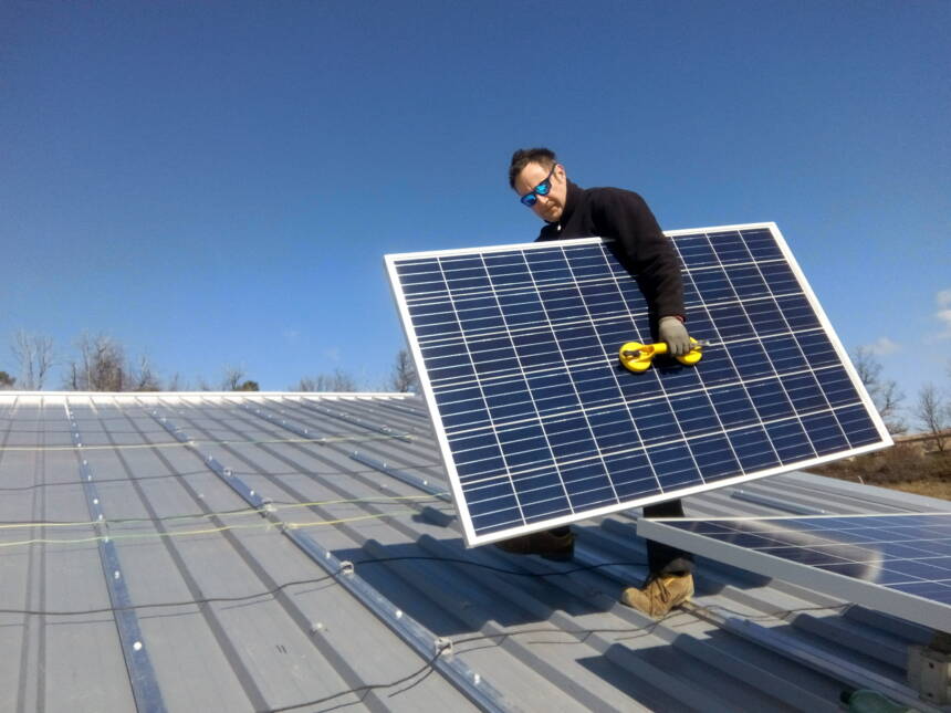 Photo : installation de panneaux PV sur le toit de la centrale du Mas de l'Escarida (36 kWc)