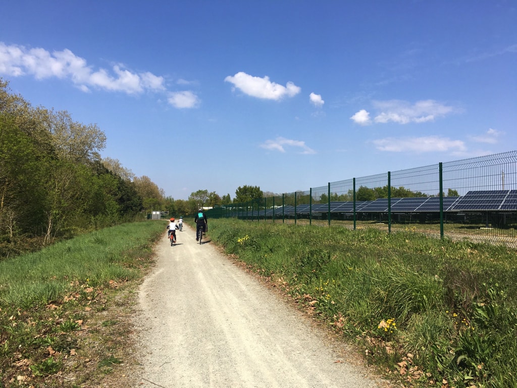 Des cyclistes passent à côté de la centrale photovoltaïque sur le chemin de La Loire à vélo