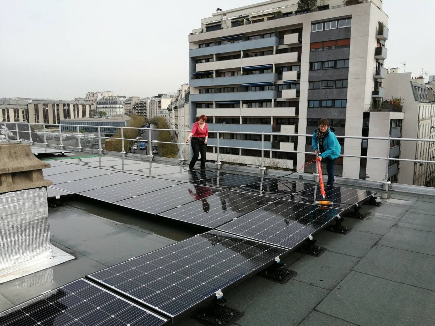 Des sociétaires sont à l'oeuvre pour nettoyer la toiture photovoltaïque de l'école Parmentier.