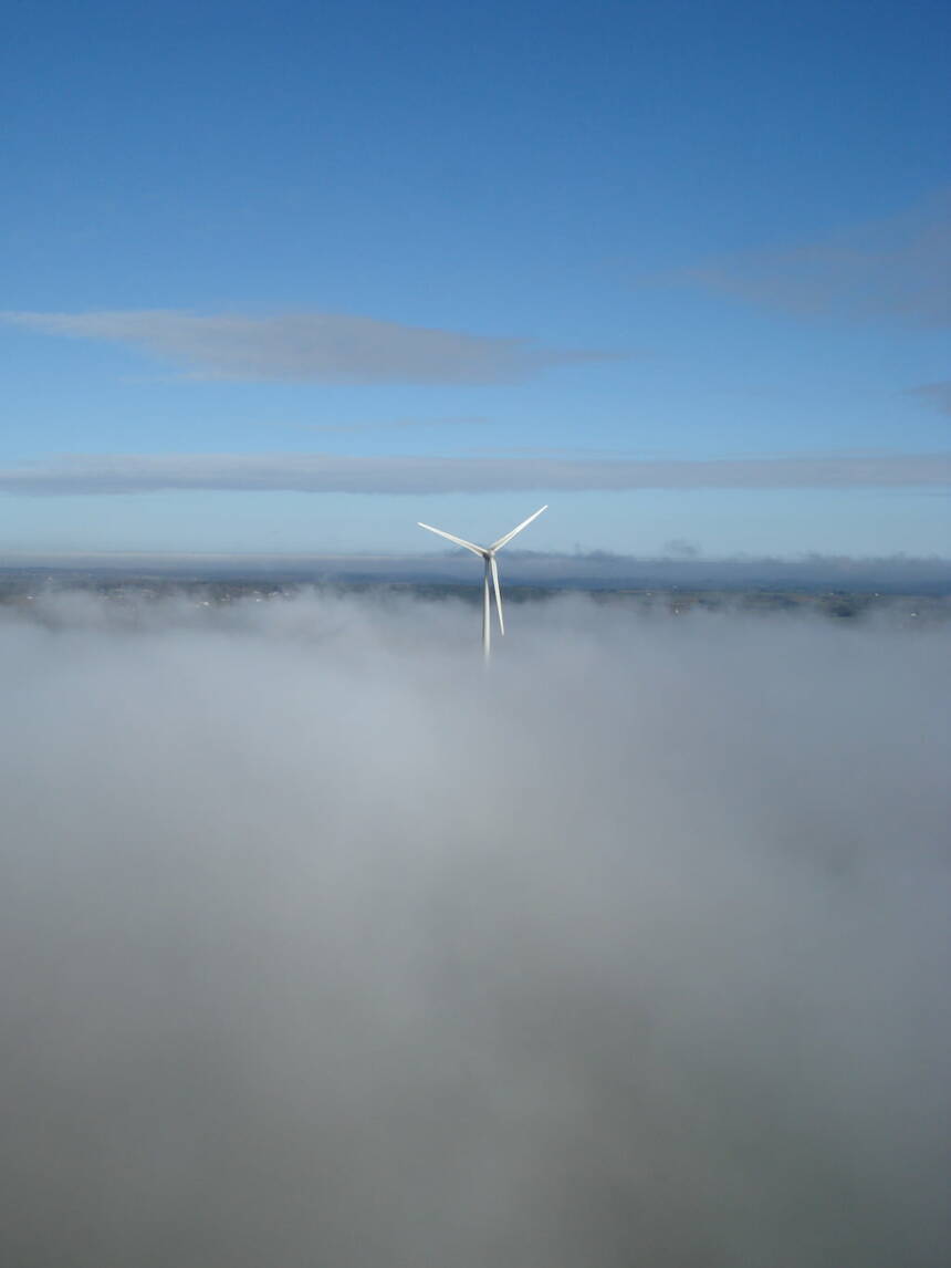 Une éolienne de Plélan-le-Grand perce un tapis de nuages.