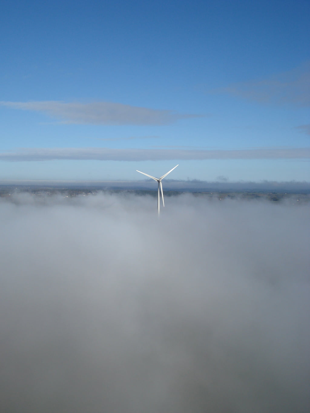 Une éolienne de Plélan-le-Grand perce un tapis de nuages.